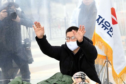 청와대 분수대앞에서 단식을 하고있는 자유한국당 황교안 대표가 비가 내린 지난 24일 지지자들을 향해 손을 흔들고 있다. 서상배 선임기자