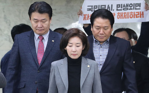 자유한국당 나경원 원내대표가 원내 대책회의에 참석하기 위해회의장에 들어서는 순간 한 진보단체 회원이 손팻말을 들고 구호를 외치고 있다. 연합뉴스