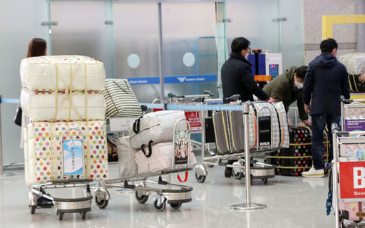 4일 오후 인천국제공항에서 공항 이용객들이 마스크가 든 수레를 운반하고 있다. 연합뉴스