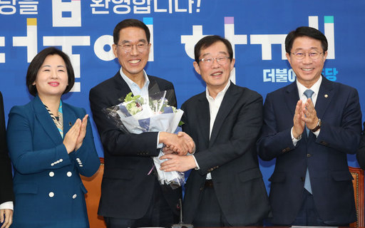 김주영 전 한국노총 위원장이 더불어민주당 입당 기자회견을 마친 후 이용득 의원(전 한국노총 위원장)에게 꽃다발을 전달받고 있다. 연합뉴스