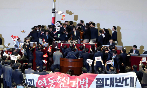 국회 방호 직원들에 둘러싸인 문희상 국회의장이 지난해 12월27일 국회 본회의에서 자유한국당(미래통합당 전신) 의원들의 격렬한 반발 속에 준연동형 비례대표제 도입을 골자로 한 공직선거법 개정안의 가결을 선포하고 있다. 하상윤 기자