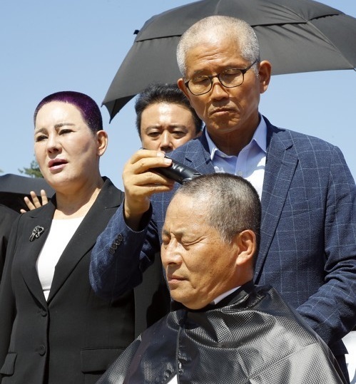 지난해 9월18일 조국 법무부 장관 사퇴 촉구 ‘릴레이 삭발 투쟁’에서 김문수 전 경기도지사가 차명진 전 의원의 머리카락을 잘라주고 있다. 연합뉴스