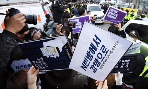 조주빈 일당의 엄벌을 요구하는 시민들이 ‘n번방에서 감방으로’라고 적힌 손팻말을 든 채 시위를 벌이고 있다. 연합뉴스