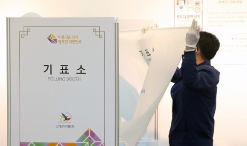 서울 종로구에 출마한 미래통합당 황교안 후보가 15일 서울 종로구 동성고등학교에 설치된 혜화동 제3투표소에서 기표소 가림막이 없다며 투표관리관에게 항의하자 관계자가 가림막을 설치하고 있다. 연합뉴스