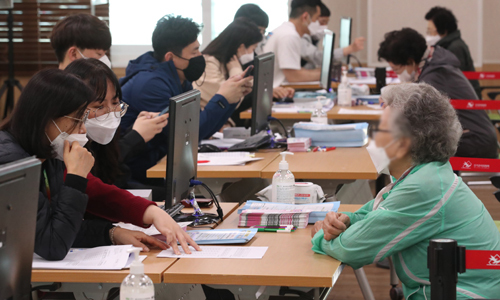 지난 23일 오후 경남 김해 장유3동 행정복지센터에서 대상자들이 긴급재난지원금을 신청하고 있다. 뉴스1