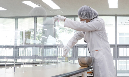 지난 4일 오후 서울 강서구 공항고등학교에서 영양사 선생님이 신종 코로나바이러스 감염증(코로나19) 예방을 위해 유리 칸막이를 설치한 급식실을 청소하고 있다. 뉴시스