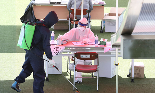 지난 13일 인천 미추홀구청에 마련된 코로나19 선별진료소에서 미추홀구 방역관계자들이 방역작업을 하고 있다.