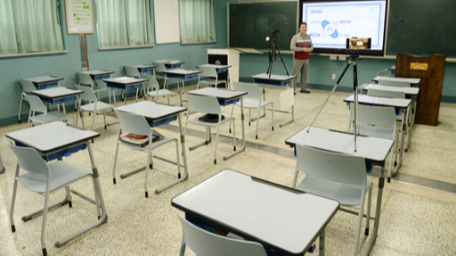 14일 전북 전주시 영생고등학교에서 한 선생님이 코로나19로 수 차례 연기된 개학으로 인해 텅 빈 교실에서 온라인 수업 녹화를 하고 있다. 뉴스1