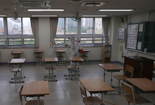 서울 이태원 클럽발 신종 코로나바이러스 감염증(코로나19) 집단 감염으로 학교들의 등교 재연기가 발표된 지난 11일 오후 서울 성동구 성수고등학교 3학년 교실에서 방역업체 관계자가 교실 소독을 하고 있다. 연합뉴스