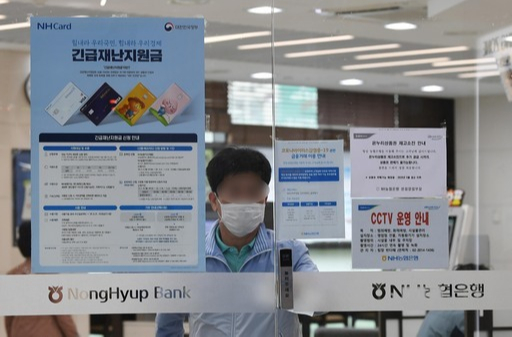 정부 긴급재난지원금 현장 접수 시행 첫날인 18일 오전 서울 중구 농협은행 본점영업부 입구에 긴급재난지원금 신청 안내문이 붙어 있다. 남정탁 기자