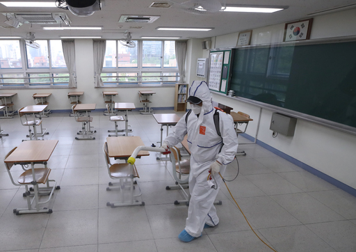 서울 이태원 클럽발 신종 코로나바이러스 감염증(코로나19) 집단 감염으로 학교들의 등교 재연기가 발표된 지난 11일 오후 서울 성동구 성수고등학교 3학년 교실에서 방역업체 관계자가 교실 소독을 하고 있다. 연합뉴스