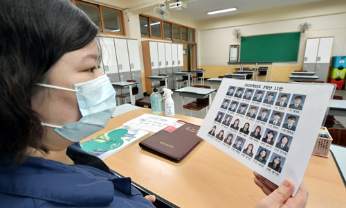 79일 만에 등교수업… 반가운 얼굴들 고등학교 3학년 학생들의 등교를 하루 앞둔 19일 서울 은평구 선정고등학교 3학년11반 담임 김은성 선생님이 학생들의 사진이 담긴 출석부를 살펴보고 있다. 코로나19 사태로 등교가 5번 미뤄진 끝에 고3 학생들은 79일 만에 학교에서 수업을 받게 된다. 하상윤 기자