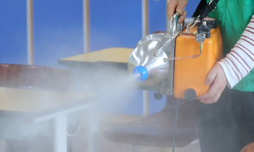 고3 학생들의 등교를 하루 앞둔 19일 오후 서울 영등포구 여의도여고에서 새마을지도자영등포구협의회 관계자가 고3 학생들의 교실 방역 작업을 하고 있다. 연합뉴스