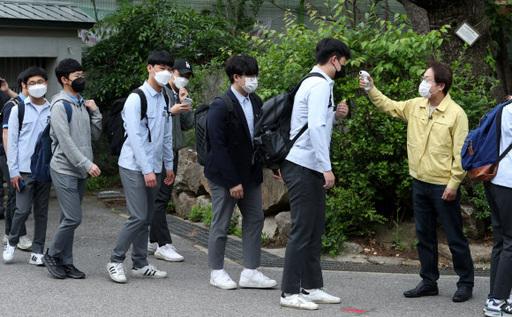 코로나19로 등교 개학이 미뤄진 지 80일 만에 등교를 시작한 20일 오전 서울 종로구 경복고등학교에서 조희연 서울시교육감이 등교하는 학생들에게 발열 체크를 하고 있다. 연합뉴스