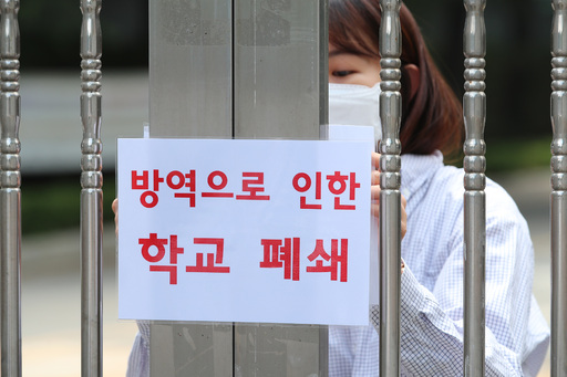 21일 신종 코로나바이러스 감염증(코로나19) 확진자가 나온 대구 수성구 노변동 대구농업마이스터고에서 학교 관계자가 출입문에 학교 폐쇄 안내문을 붙이고 있다. 대구=뉴스1