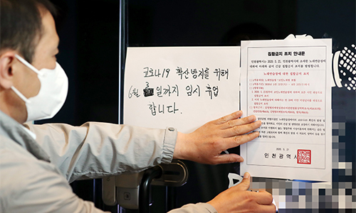 지난 21일 오후 인천시 연수구 한 코인노래방에서 연수구청 관계자가 집합금지 조치 안내문을 부착하고 있다. 연합뉴스