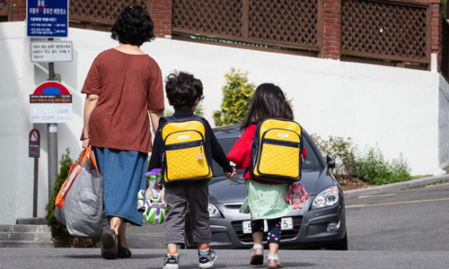 지난 12일 서울시내 한 어린이집에서 한 할머니가 두 손자 손녀를 긴급돌봄을 위해 등원시키고 있다. 뉴스1