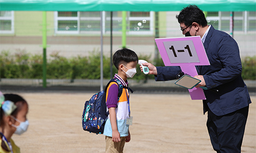 2차 등교일인 27일 대구 수성구 범어동 동도초등학교에서 선생님이 1학년 신입생의 발열 여부를 체크하고 있다. 연합뉴스