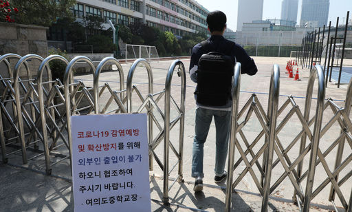 29일 오전 여의도중학교 관계자가 학교 정문으로 들어가고 있다. 이 학교는 여의도 학원강사와 수강생 코로나19 확진으로 이날 예정된 학생 등교를 원격수업으로 변경했다. 연합뉴스