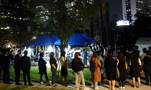 밤 늦도록 북적이는 선별진료소 28일 서울 중구 서소문역사공원에 마련된 코로나19 임시 선별진료소에서 근처 직장인과 주민들이 검사를 받기 위해 밤늦도록 줄을 서 대기하고 있다. 중구는 지난 26일 KB생명보험 직원 등 8명이 코로나19 확진 판정을 받은 것과 관련해 이곳에 임시 선별진료소를 운영 중이다. 연합뉴스