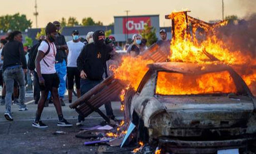 흑인 질식사에 항의하는 시위대가 지난 5월 28일 미네소타주 미니애폴리스 도심에서 차량에 불을 지르고 있다. AFP연합뉴스