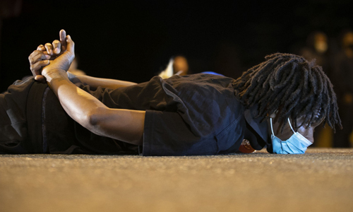 ‘사망 당시 재연’ 항의·추모 흑인 조지 플로이드가 경찰관의 과잉진압으로 사망한 사건과 관련해 1일(현지시간) 미국 노스캐롤라이나주 더럼에서 열린 시위에서 한 남성이 플로이드 사망 당시 모습으로 도로에 엎드려 추모와 항의의 뜻을 나타내고 있다. 플로이드는 지난달 25일 수갑을 뒤로 찬 채 땅바닥에 엎드린 상태에서 8분46초 동안 경찰관 무릎에 목이 눌린 뒤 숨졌다. 더럼=AP연합뉴스