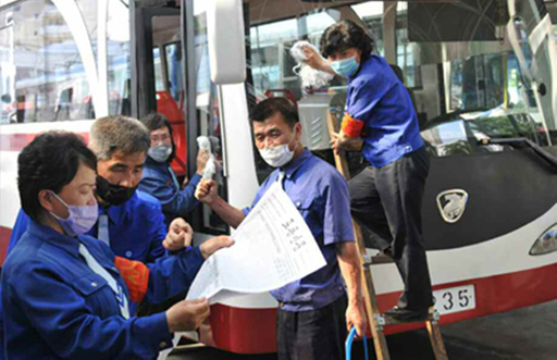 북한 노동신문이 7일 탈북민들의 대북전단 살포를 규탄하는 각계의 반응을 보도했다. 사진은 마스크를 쓴 채로 노동신문을 보며 대화를 나누고 있는 연못무궤도전차사업소 역전대대 노동자들. 노동신문 홈페이지 캡처. 연합뉴스