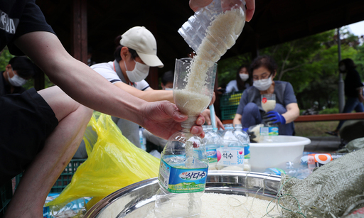 탈북단체 '큰샘' 회원들이 18일 서울 강남구 일원동 일대에서 북한에 보낼 쌀을 페트병에 담고 있다. 이들은 오는 21일 강화 석모도에서 페트병에 쌀과 마스크를 담아 북한에 보낼 예정이다. 뉴시스