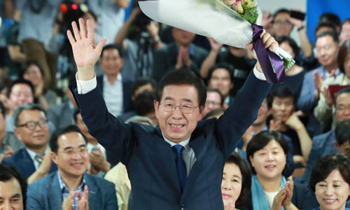 2018년 6월 지방선거에서 최초로 3선 서울시장에 당선된 날 축하 꽃다발을 들고 인사하는 모습. 연합뉴스