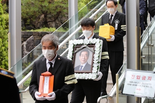 고(故) 박원순 서울시장의 영정과 유골함이 13일 서울 서초구 서울추모공원에서 화장을 마친 뒤 고인의 고향인 경남 창녕으로 가는 운구차로 옮겨지고 있다. 연합뉴스