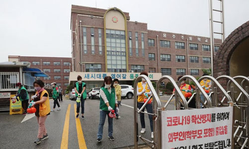 지난 6일 오전 광주 북구의 한 초등학교에서 동행정복지센터 직원들과 봉사단체 회원들이 방역하고 있다. 연합뉴스