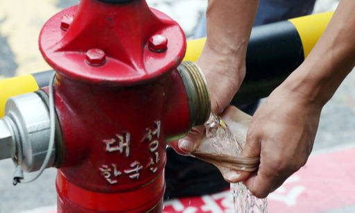 인천시 계양구 지역 상수도관과 연결된 한 소화전에서 인천상수도사업본부 북부수도사업소 직원들이 스타킹을 이용해 수질을 점검하고 있다. 연합뉴스
