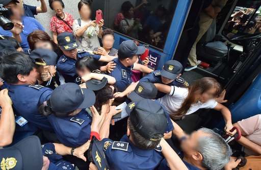 지난 12일 오전 제주지법에서 전 남편을 잔혹하게 살해한 뒤 시신을 훼손·유기한 혐의를 받는 고유정(36)의 첫 공판이 열린 가운데 시민들이 호송차에 오르는 고유정의 머리채를 잡아 당기고 있다. 제주=뉴시스