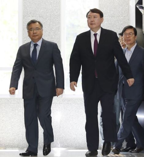 2017년 5월 19일 서울중앙지검장으로 승진 임명된 윤석열 당시 대전고검 검사(오른쪽 두번째)가 19일 오후 서울 서초구 특별검사 사무실 앞에서 취재진 질문에 답하고 있다. 왼쪽은 박영수 특별검사. 연합뉴스