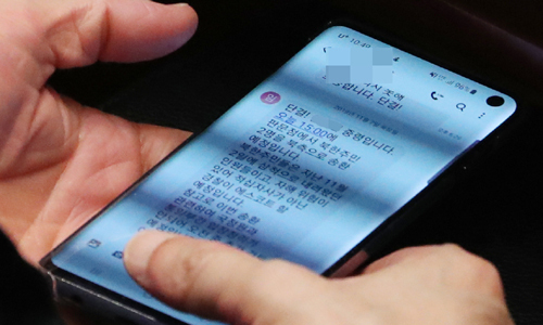 청와대 대통령비서실 관계자가 7일 국회 예산결산특위 전체회의에서 휴대폰으로 북한 주민송환 관련 메시지를 보고 있다. 뉴스1