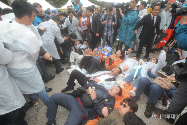 광주/아시아투데이 정재훈 기자 = 제39주년 5·18 민주화운동 기념식을 앞둔 18일 오전 광주 북구 국립5.18민주묘지에서 황교안 자유한국당 대표가 입장하려 하자 광주 시민들과 진보 단체 회원들이 바닥에 누워 항의를 하고 있다.