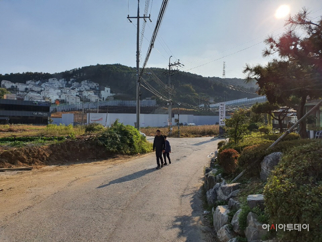 광교산 성복동 도시계획도로 초입, 저멀리 개발업자가 개발하기위한 부지의 펜스가 보일뿐 지나가는 차량은 거의 보기 힘들다./사진=홍화표 기자
