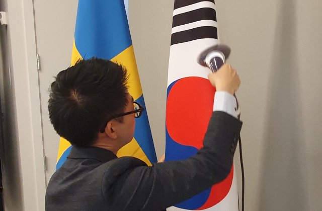 14일 오후(현지시간) 스웨덴 스톡홀름 앳식스호텔에서 열린 한- 스웨덴 비즈니스 서밋에 외교부 직원들이 스팀다리미로 태극기의 주름을 펴고 있다. 박영대 기자. sannae@donga.com