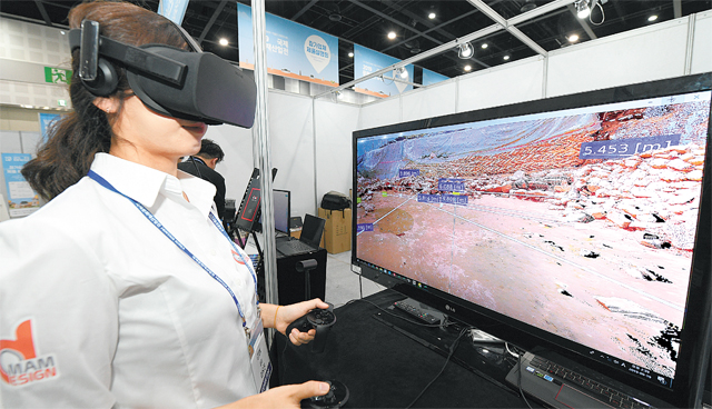 19일 경북 경주시에서 열린 ‘2019 국제문화재산업전’에서 문화재 관련 가상현실(VR) 시스템을 시연하는 모습. 문화재 발굴 현장을 3차원 데이터로 기록하고 이를 재현한 3D시스템즈코리아와 대구의 기업 CTOK의 컨소시엄 부스다. 문화재청 제공