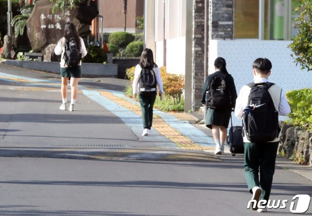 (제주=뉴스1) 신종코로나바이러스(코로나19) 확산으로 미뤄졌던 고3 등교가 시작된 20일 제주시 아라일동 제주여자고등학교에서 마스크를 쓴 학생들이 거리두기를 하며 학교 안으로 향하고 있다.2020.5.20/뉴스1