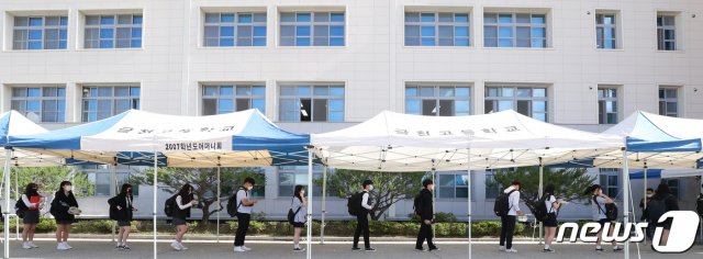 (청주=뉴스1) 고등학교 3학년 등교 개학이 시작된 20일 오전 충북 청주시 상당구 금천고등학교에서 학생들이 체온 검사를 위해 거리를 두고 서 있다. 2020.5.20/뉴스1