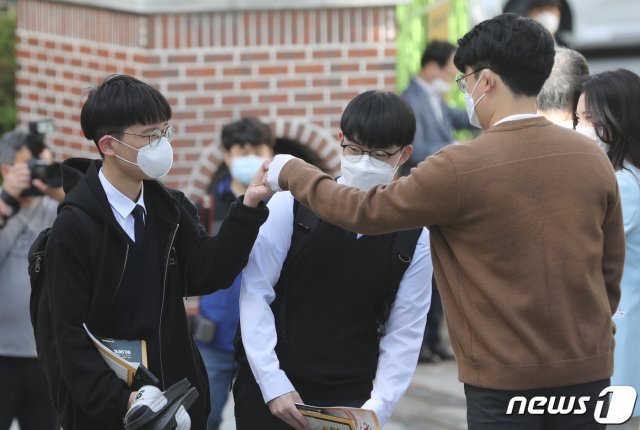 (청주=뉴스1) 고등학교 3학년 등교 개학이 시작된 20일 오전 충북 청주시 상당구 금천고등학교에서 학생들이 교사들의 환영인사를 받으며 등교하고 있다. 2020.5.29/뉴스1