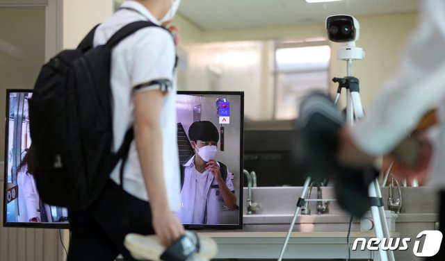 (광주=뉴스1) 신종 코로나바이러스 감염증(코로나19) 여파로 등교가 5차례나 연기되며 80일 만에 등교 수업이 시작된 20일 오전 광주고등학교에서 고3 학생들이 교실에 들어가기 앞서 열화상카메라를 통해 발열 상태를 확인하고 있다. 2020.5.20/뉴스1