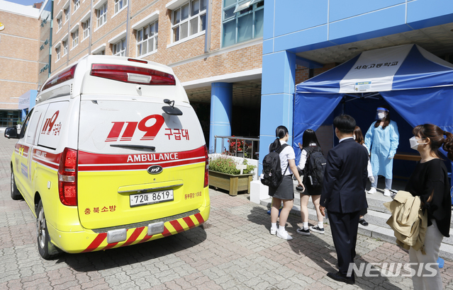 20일 올해 첫 등교에 나선 충북 청주 서원고등학교 고3 학생 2명이 고열로 119구급대를 이용해 보건소로 이동하고 있다. 뉴시스