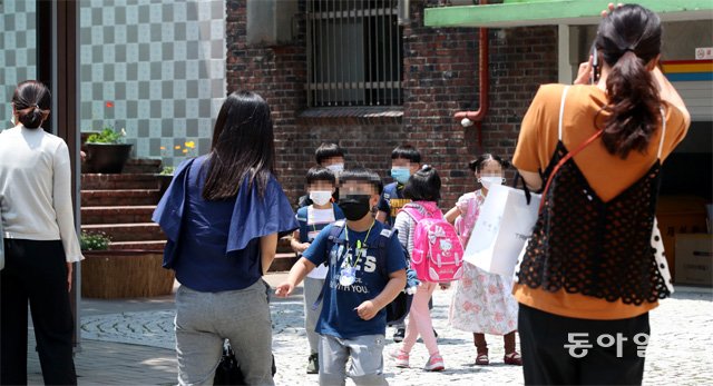 “우리 아이 괜찮으려나…” 29일  서울 종로구 매동초교 학생들이 수업을 마치고 하교하고 있다. 수도권에 있는 물류센터와 식당, 학원 등을 중심으로 신종  코로나바이러스 감염증 확진자가 늘어나자 정부는 이날 수도권 유치원과 초중학교의 등교 학생 수를 전체의 3분의 1 아래로 조정한다고  밝혔다. 장승윤 기자 tomato99@donga.com
