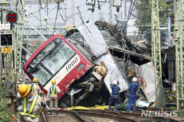 【요코하마=AP/뉴시스】5일 일본 도쿄 인근 요코하마 철길에서 열차와 트럭이 충돌해 현장에서 관계자들이 대응하고 있다. 현지 경찰과 소방당국은 트럭 한 대가 철길을 건너려고 진입하다가 열차와 충돌해 기관차가 탈선하고 트럭에 불이 붙었으며 30여 명이 다쳤다고 밝혔다. 2019.09.05.