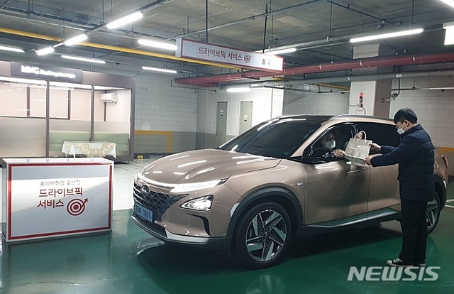 [울산=뉴시스] 박수지 기자 = 롯데백화점 울산점이 코로나19 확산 방지를 위해 '드라이브픽 서비스'를 도입한 가운데 손님이 백화점 주차장에서 상품을 수령하고 있다. 2020.03.12.(사진=롯데백화점 울산점 제공)  photo@newsis.com