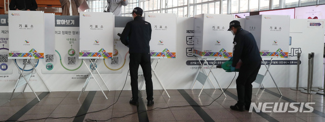 [서울=뉴시스]김병문 기자 = 제21대 국회의원선거 사전투표를 하루 앞둔 9일 오후 서울 용산구 서울역 대합실에 설치된 남영동 사전투표소에서 방역 관계자들이 기표소를 방역 소독 작업하고 있다. 2020.04.09.  photo@newsis.com