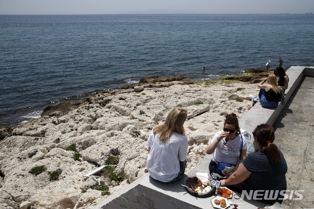 [피레우스=AP/뉴시스] 5월20일(현지시간) 그리스 아테네 서남쪽 항구도시 피레우스 해변에서 식사 중인 사람들. 2020.06.03.