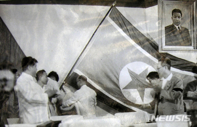 [서울=뉴시스] 1948년 7월 8일 열린 북조선인민회의 제5차 회의에서 김두봉이 회의장 정면에 걸린 태극기를 ‘공화국기’와 바꾸어 걸고 있다. (사진=미디어한국학 제공) 2020.07.19.photo@newsis.com